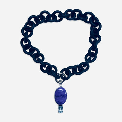 BLACK RUBBER NECKLACE WITH PENDENT BEZEL SET IN SILVER WITH A LARGE CHAROITE STONE AND A LIGHT BLUE TOPAZ STONE.