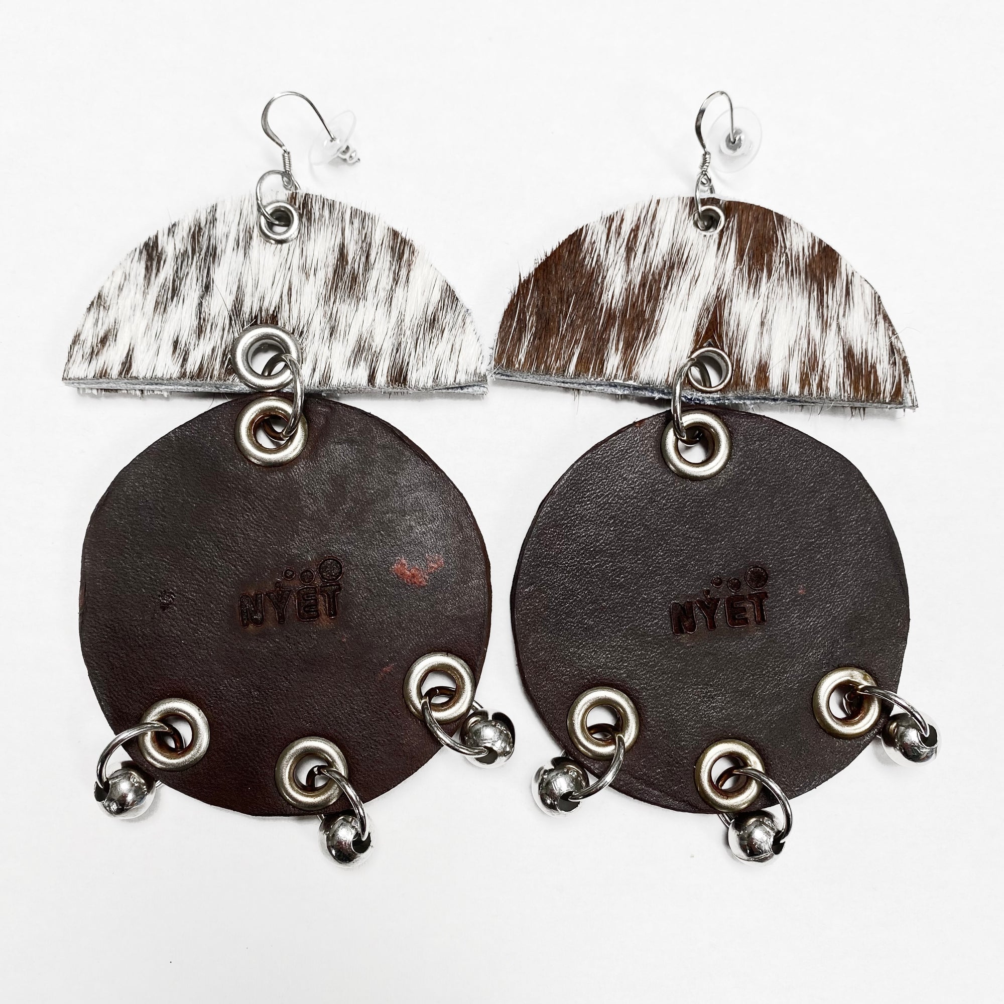 WIDE HAIR-ON AND TANNED COWHIDE EARRINGS WITH SEMI CIRCLE AND LARGE CIRCLE PENDANTS ADORNED WITH STAINLESS STEEL BEADS. by NYET Jewelry
