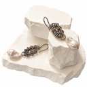 A pair of dangle earrings displayed on rough white stone blocks against a white background. Each earring has a stainless steel metall chain link section, a silver fishhook ear wire, and a baroque pearl drop.