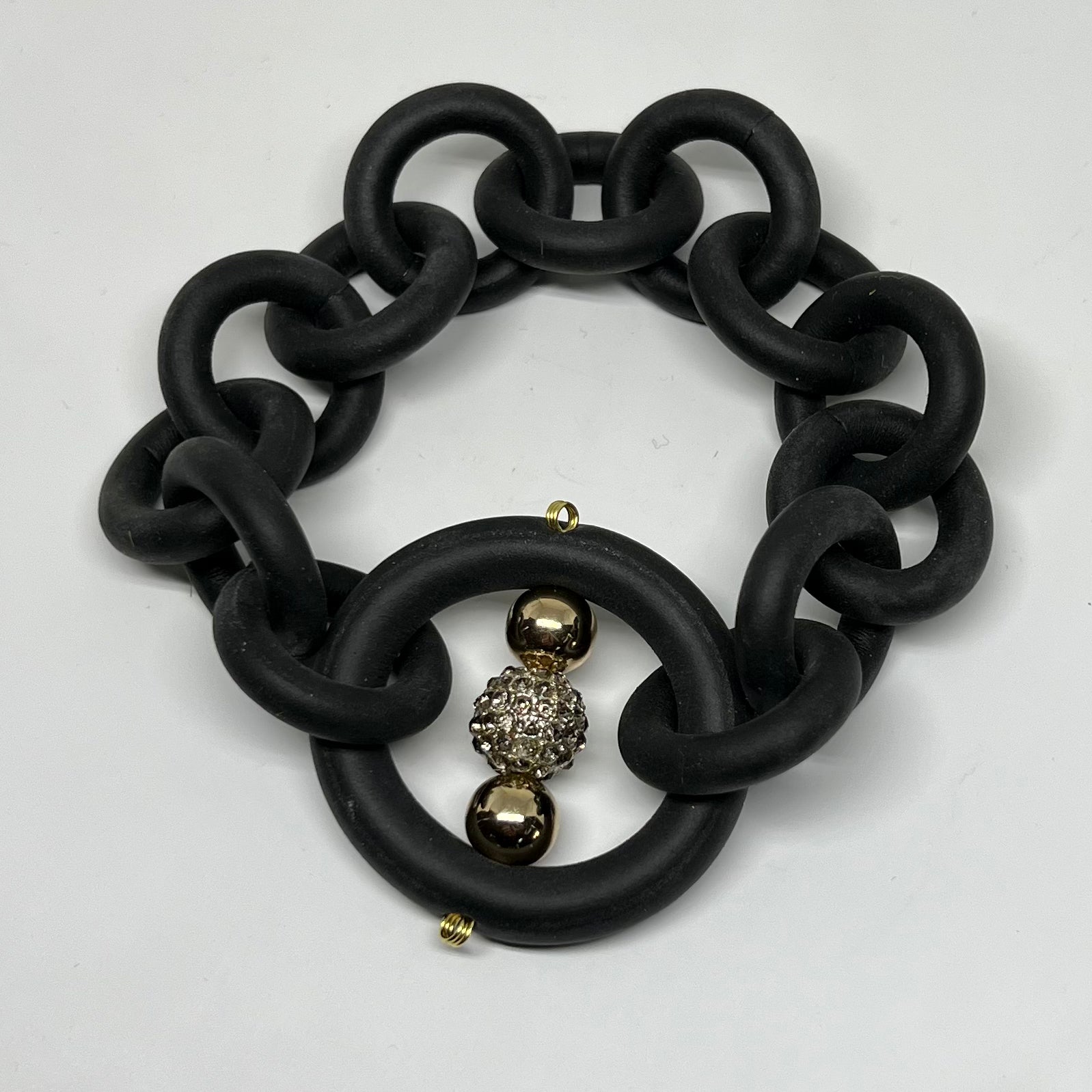 BLACK RUBBER BRACELET WITH CZ AND GOLD TONE METAL BEADS. by nyet jewelry