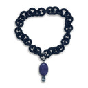 BLACK RUBBER NECKLACE WITH PENDENT BEZEL SET IN SILVER WITH A LARGE CHAROITE STONE AND A LIGHT BLUE TOPAZ STONE.
