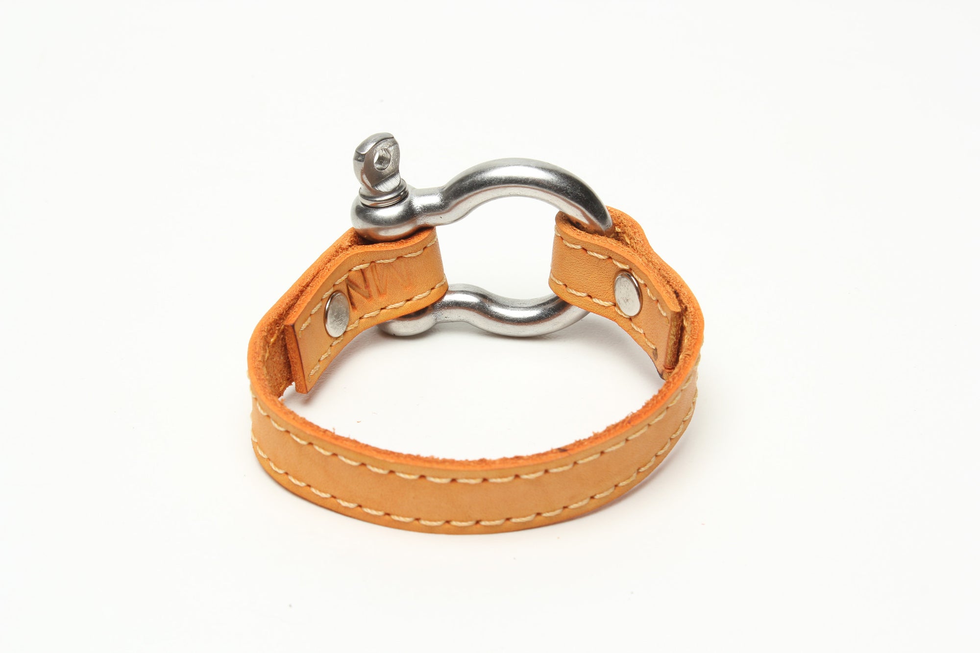 SIGNATURE STITCHED LEATHER AND STAINLESS STEEL SHACKLE BY NYET JEWELRY.