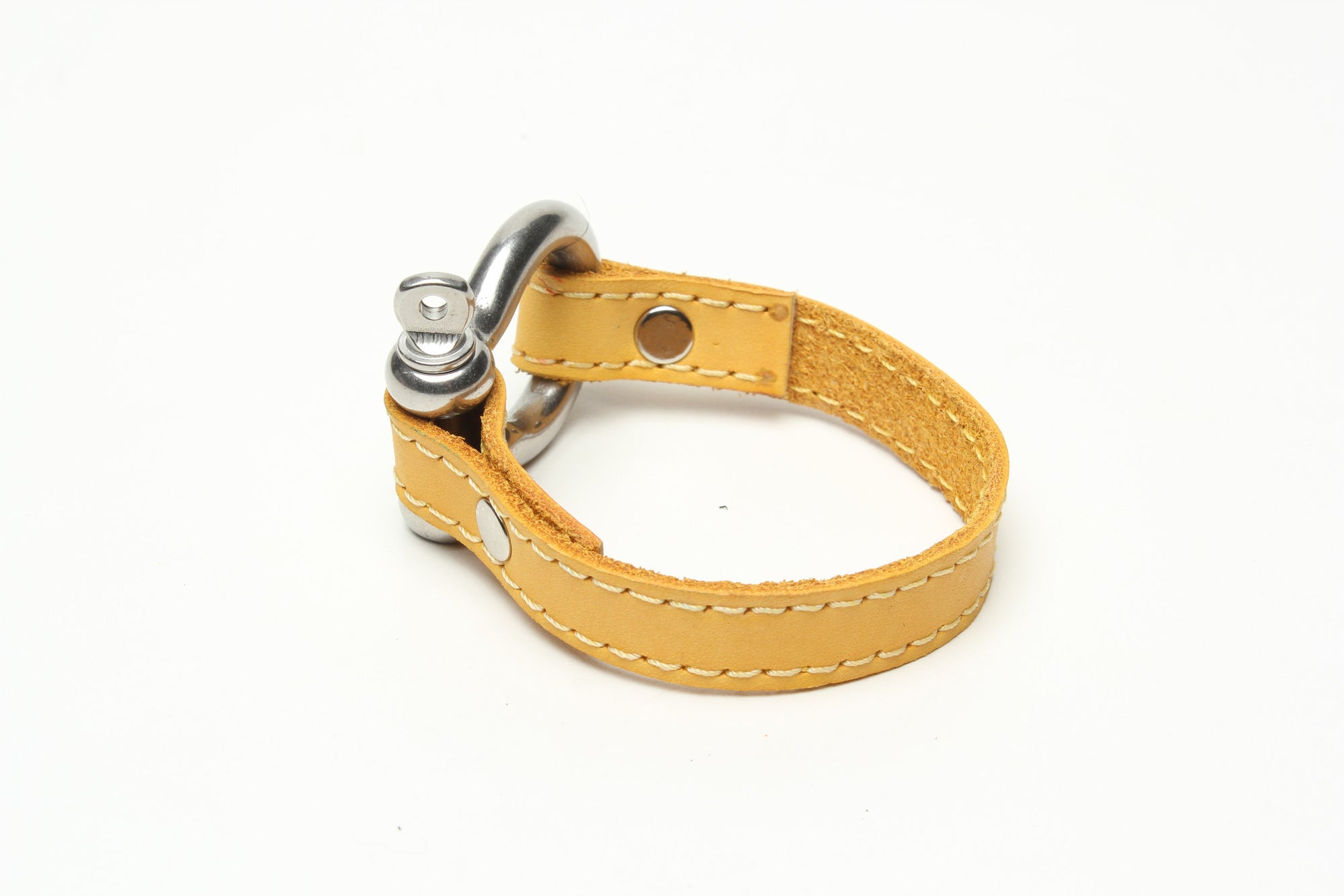 SIGNATURE STITCHED LEATHER AND STAINLESS STEEL SHACKLE BY NYET JEWELRY.