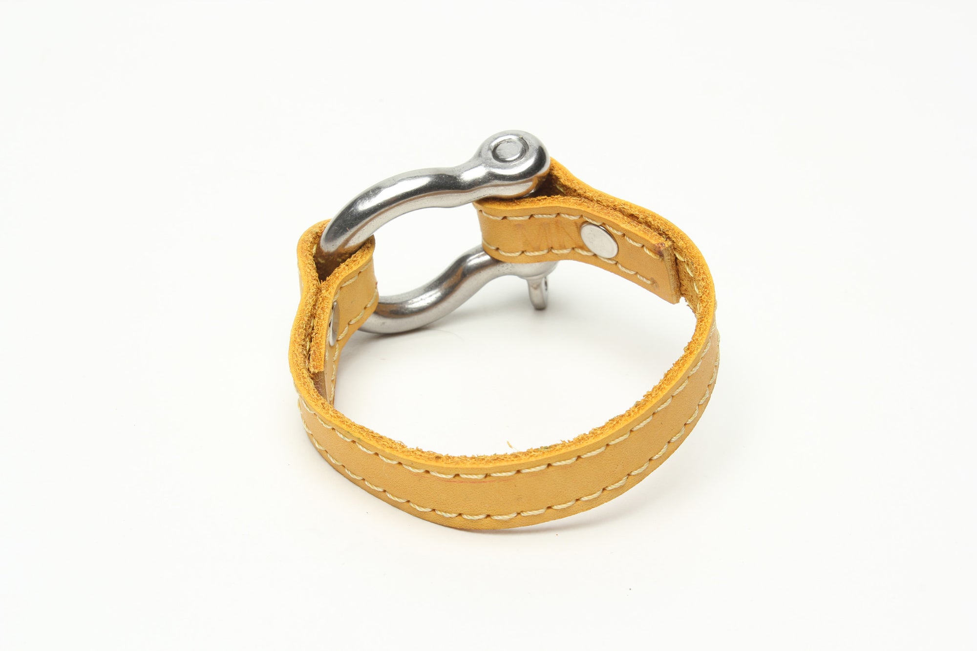 SIGNATURE STITCHED LEATHER AND STAINLESS STEEL SHACKLE BY NYET JEWELRY.