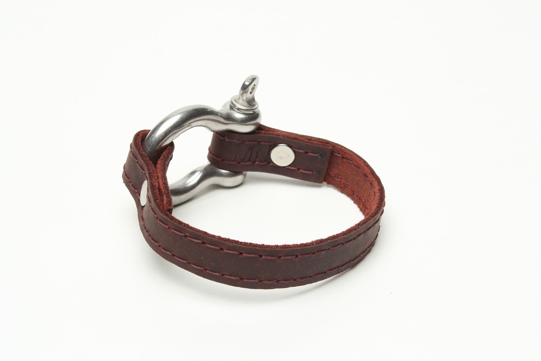 SIGNATURE STITCHED LEATHER AND STAINLESS STEEL SHACKLE BY NYET JEWELRY.