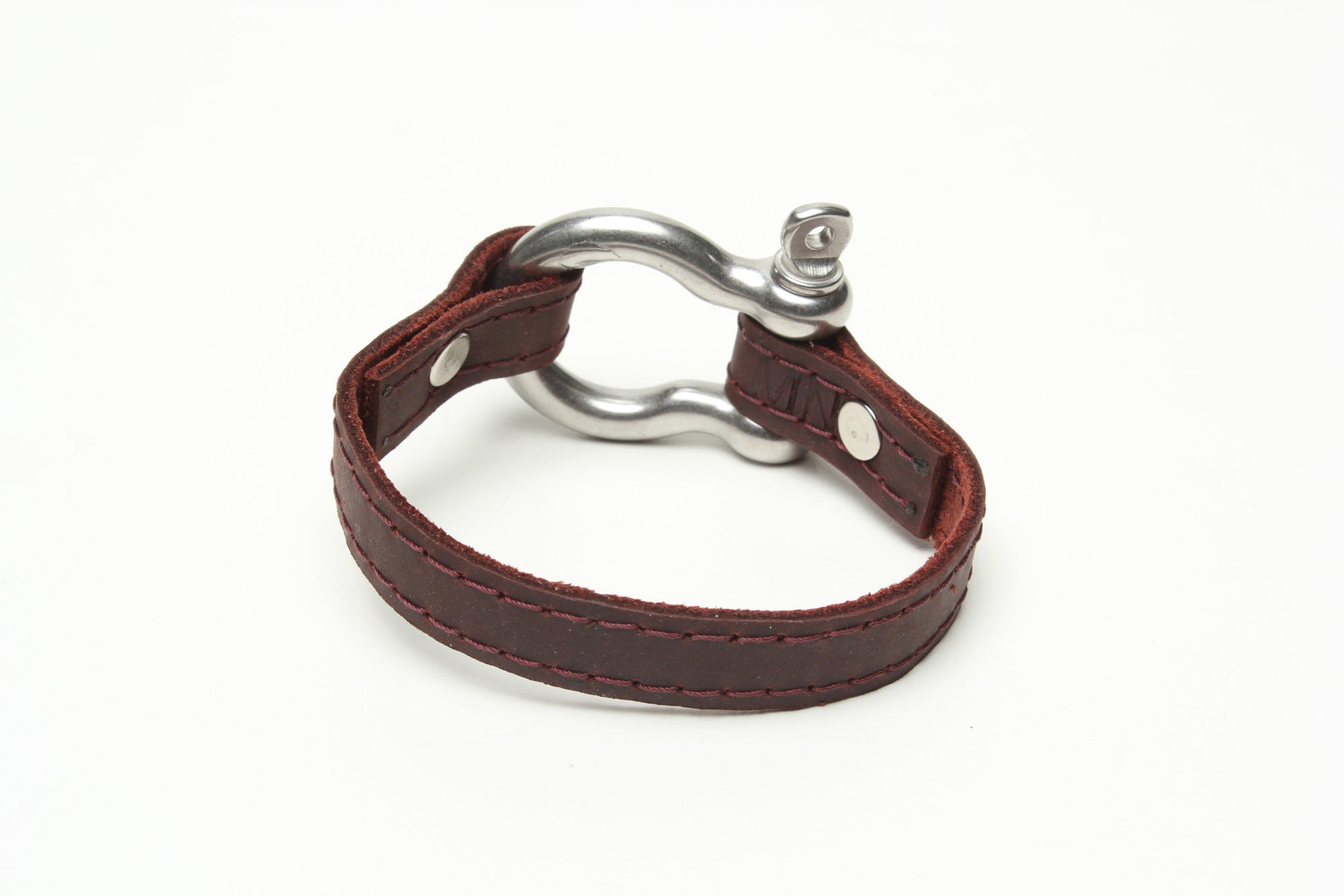 SIGNATURE STITCHED LEATHER AND STAINLESS STEEL SHACKLE BY NYET JEWELRY.