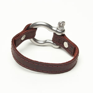 SIGNATURE STITCHED LEATHER AND STAINLESS STEEL SHACKLE BY NYET JEWELRY.