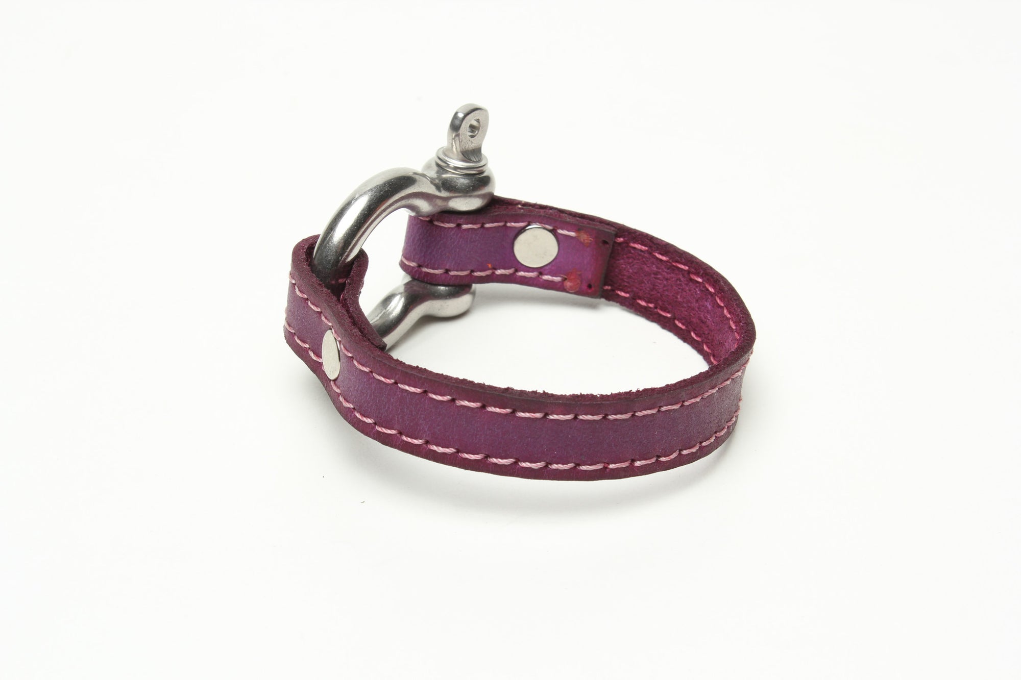 SIGNATURE STITCHED LEATHER AND STAINLESS STEEL SHACKLE BY NYET JEWELRY.