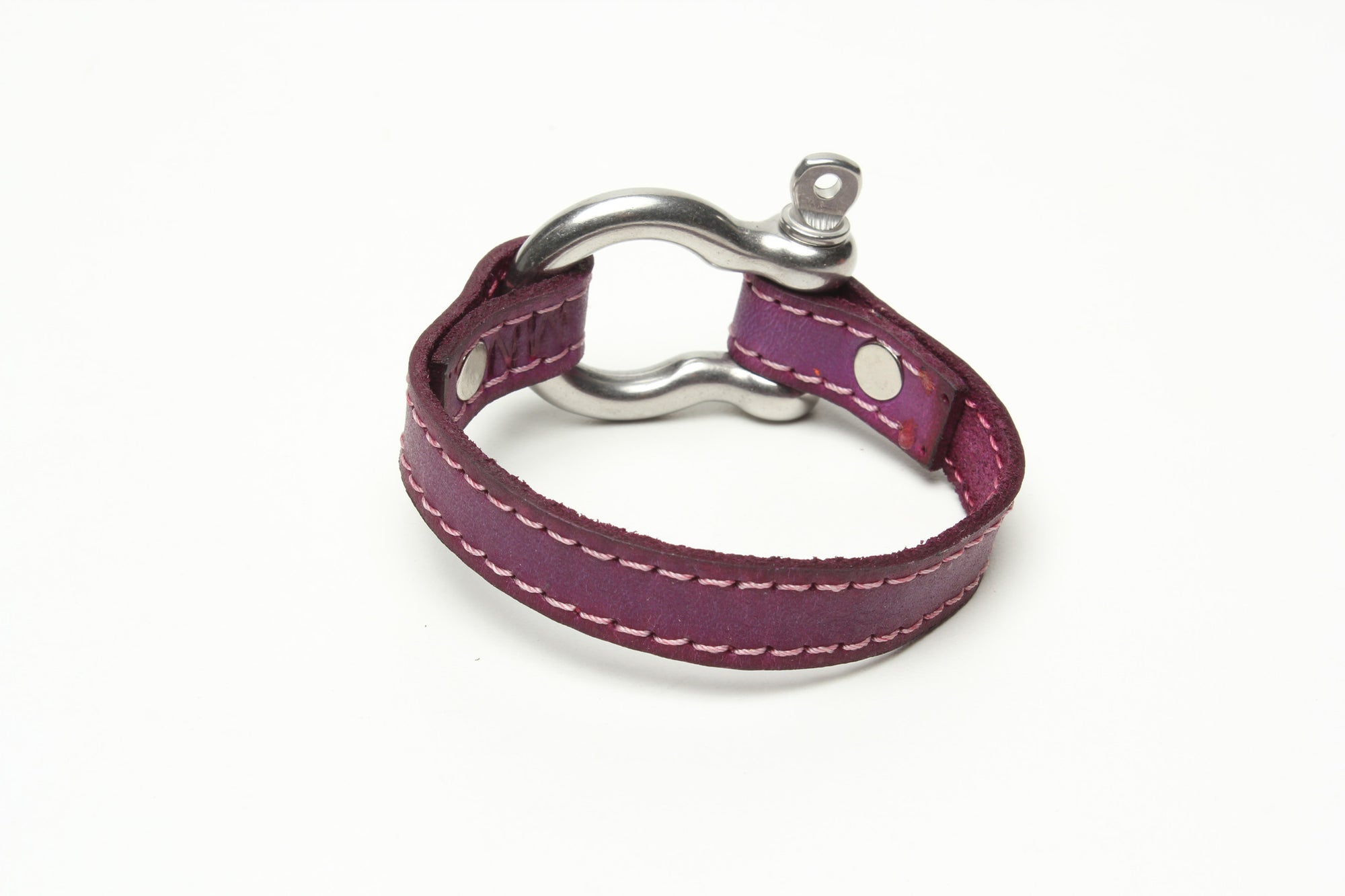 SIGNATURE STITCHED LEATHER AND STAINLESS STEEL SHACKLE BY NYET JEWELRY.