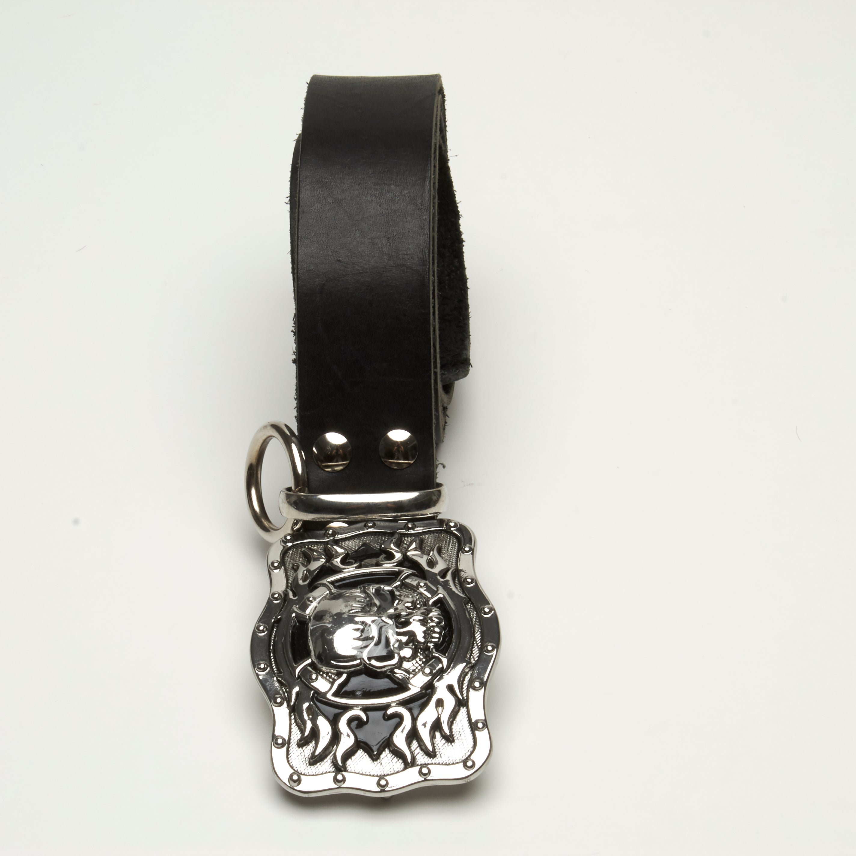 LEATHER BELT WITH HEAVY METAL AND BLACK ENAMEL SKULL BUCKLE ADORNED WITH THICK RING AT BELT LOOP. by NYET Jewelry.