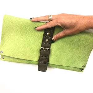 GREEN HAIR-ON COWHIDE CLUTCH WITH DETAILED UTILITY LEATHER STRAP AND BELT BUCKLE-STYLE CLOSURE by nyet jewelry