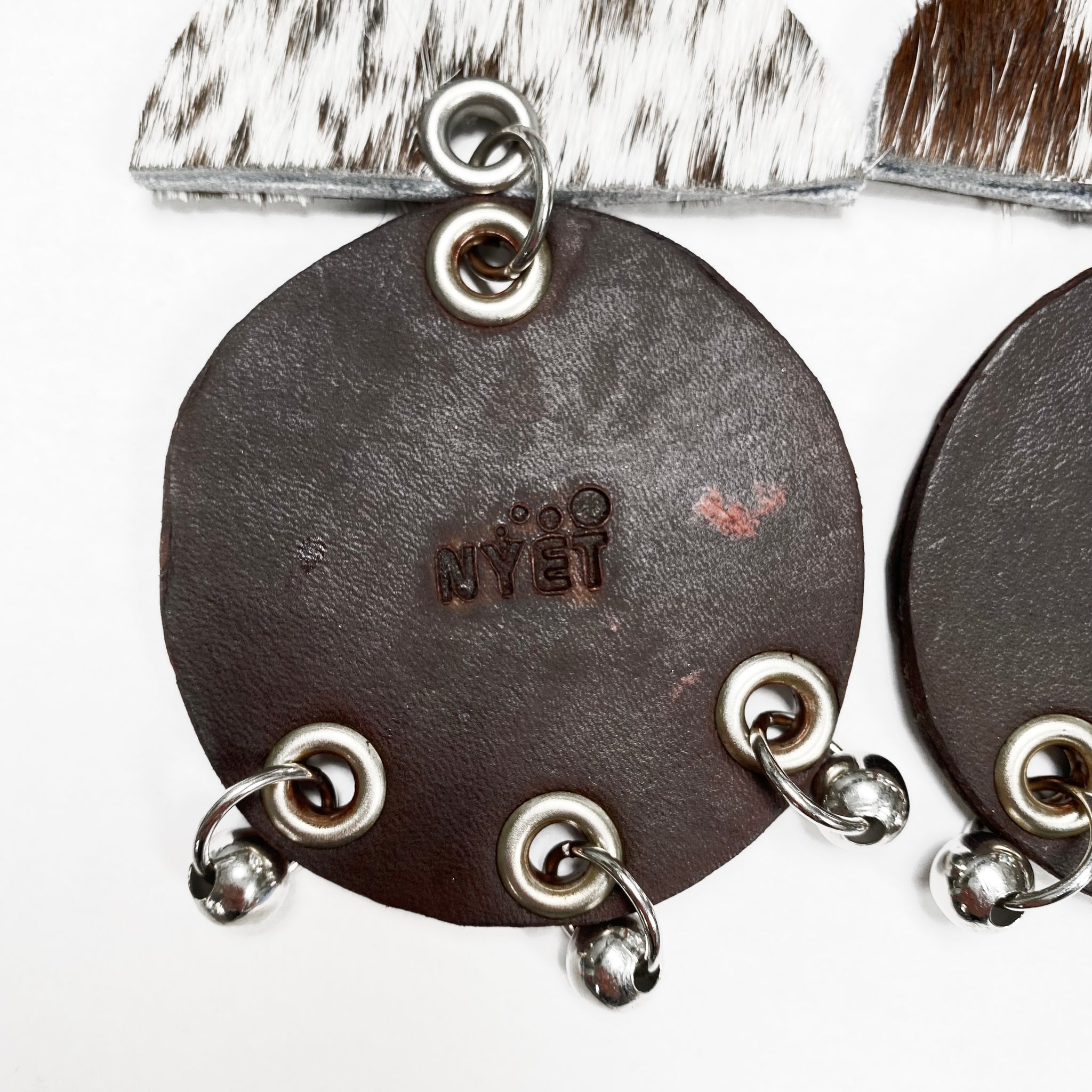 WIDE HAIR-ON AND TANNED COWHIDE EARRINGS WITH SEMI CIRCLE  AND LARGE CIRCLE PENDANTS ADORNED WITH STAINLESS STEEL BEADS. by NYET Jewelry
