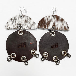 WIDE HAIR-ON AND TANNED COWHIDE EARRINGS WITH SEMI CIRCLE  AND LARGE CIRCLE PENDANTS ADORNED WITH STAINLESS STEEL BEADS. by NYET Jewelry