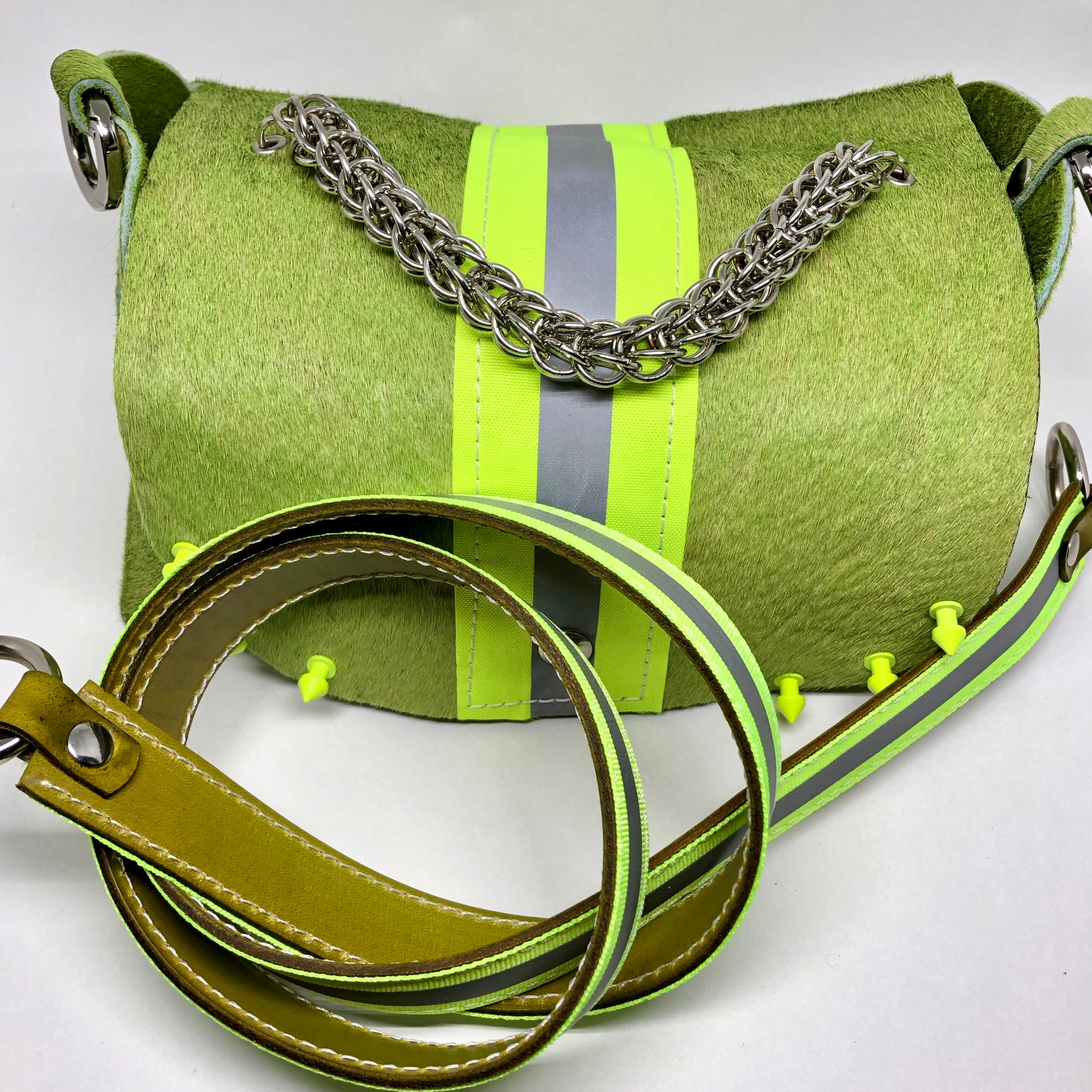 HAIR-ON COWHIDE LEATHER WITH WIDE NEON YELLOW REFLECTIVE TRIM RIVETED DAY-TO-EVENING BAG WITH STAINLESS STEEL METAL HARDWARE, CHAIN MAILLE HANDLE AND REMOVABLE SHOULDER STRAP.